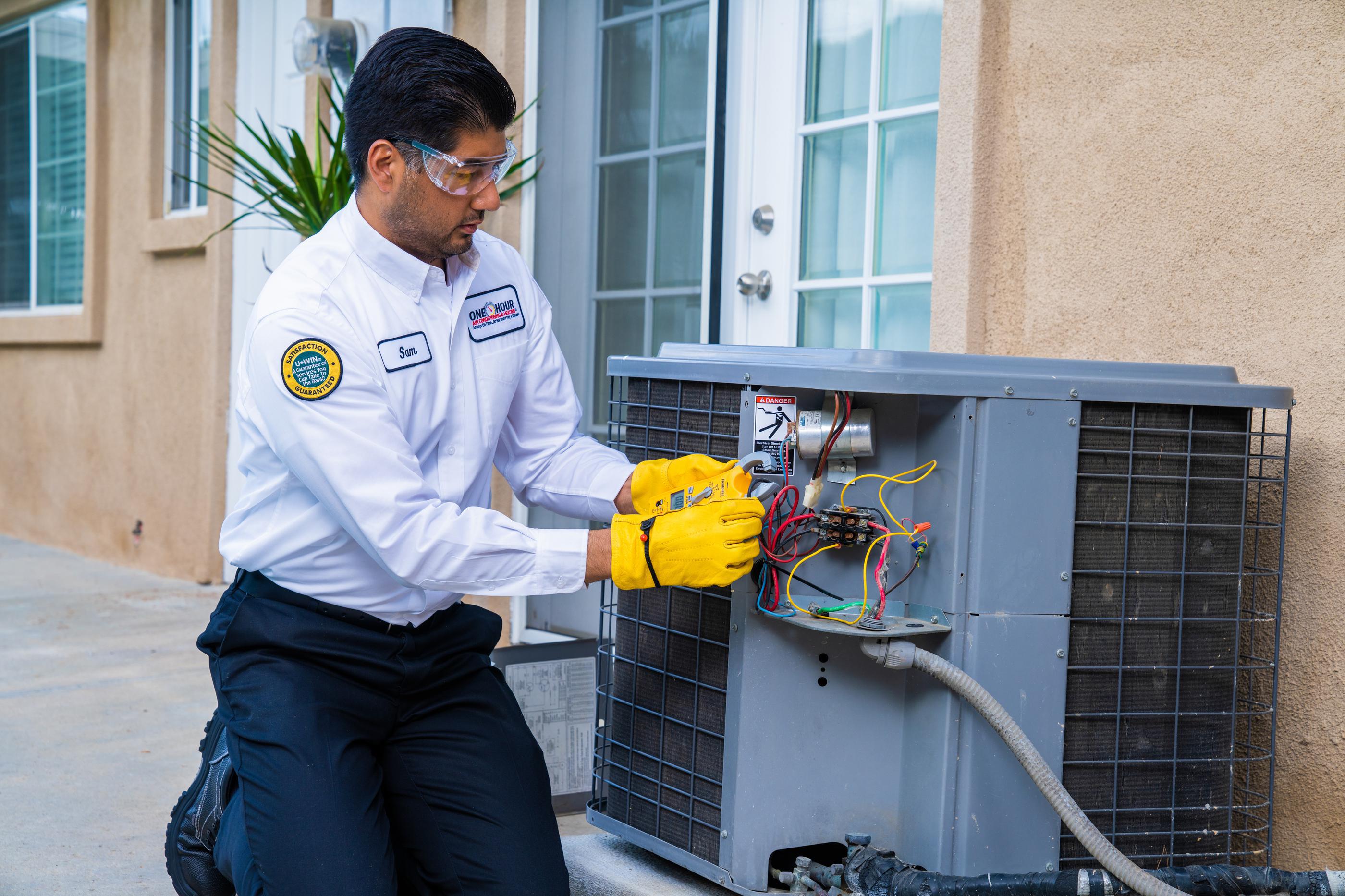 Technician repairing outdoor air conditioning unit